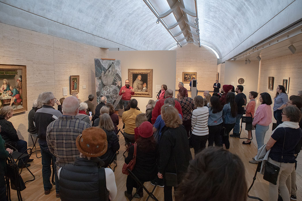 a group of visitors listening to a Kimbell docent speak