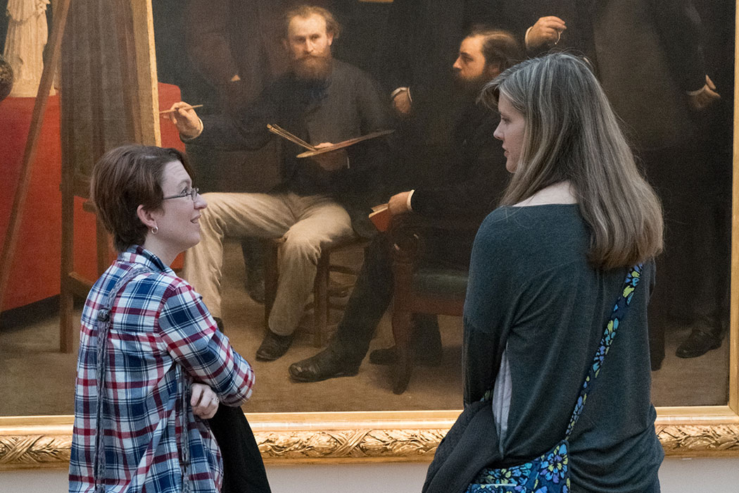 college students in discussion in front of a painting