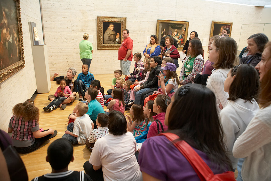 a Kimbell docent sitting with a group of young visitors looking at a painting