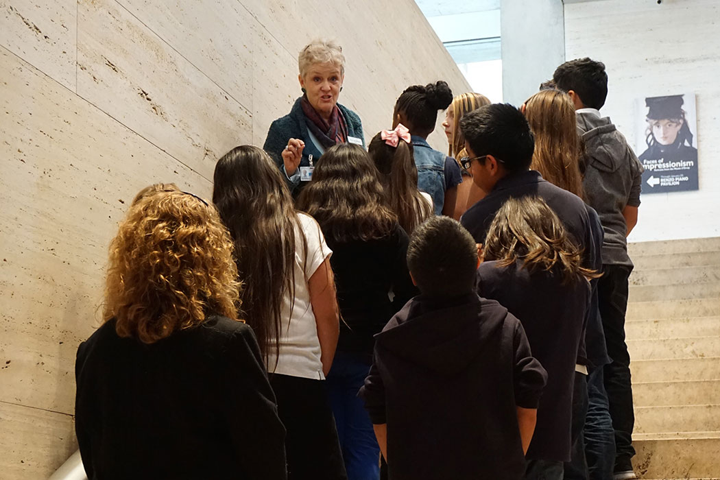 a Kimbell docent speaking to a group of students on a staircase