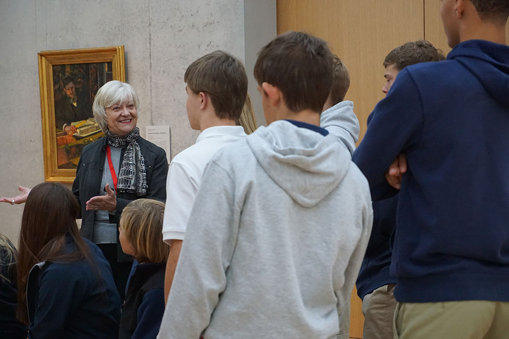 a Kimbell docent smiling at a group of students