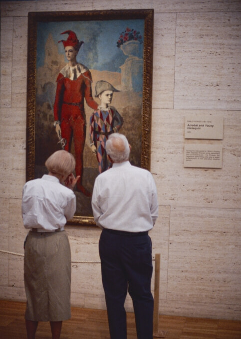 two people admiring a painting