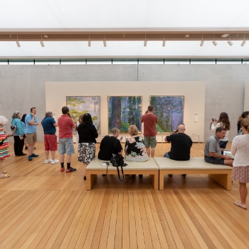 visitors admiring paintings in the Monet: The Late Years exhibition